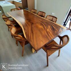 Meja Makan Trembesi Jepara berbahan kayu solid dengan serat alami dan desain live edge, dipadukan kursi rotan elegan.